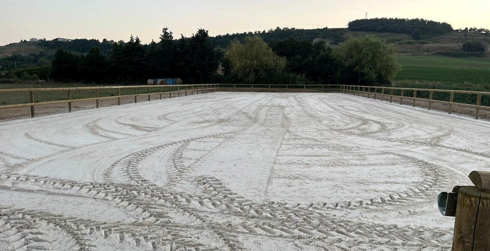 La carrière de 60 sur 20 mètres fraîchement hersée au crépuscule, les collines ardéchoises à l’horizon.